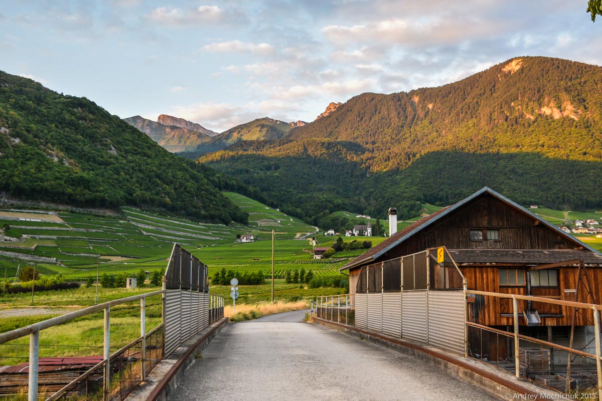 Вид на горы и швейцарскую деревню на закате.